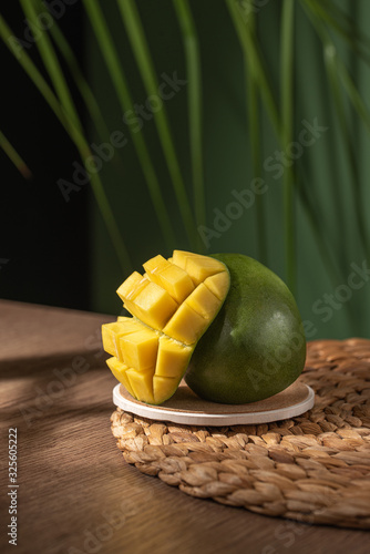 cut mango on tropical background