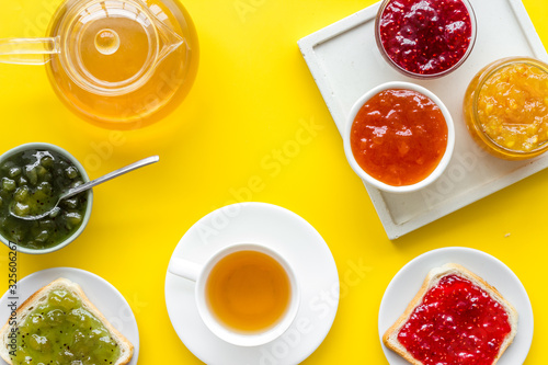 Tea party with jam. Toast, teapot, cup on yellow background