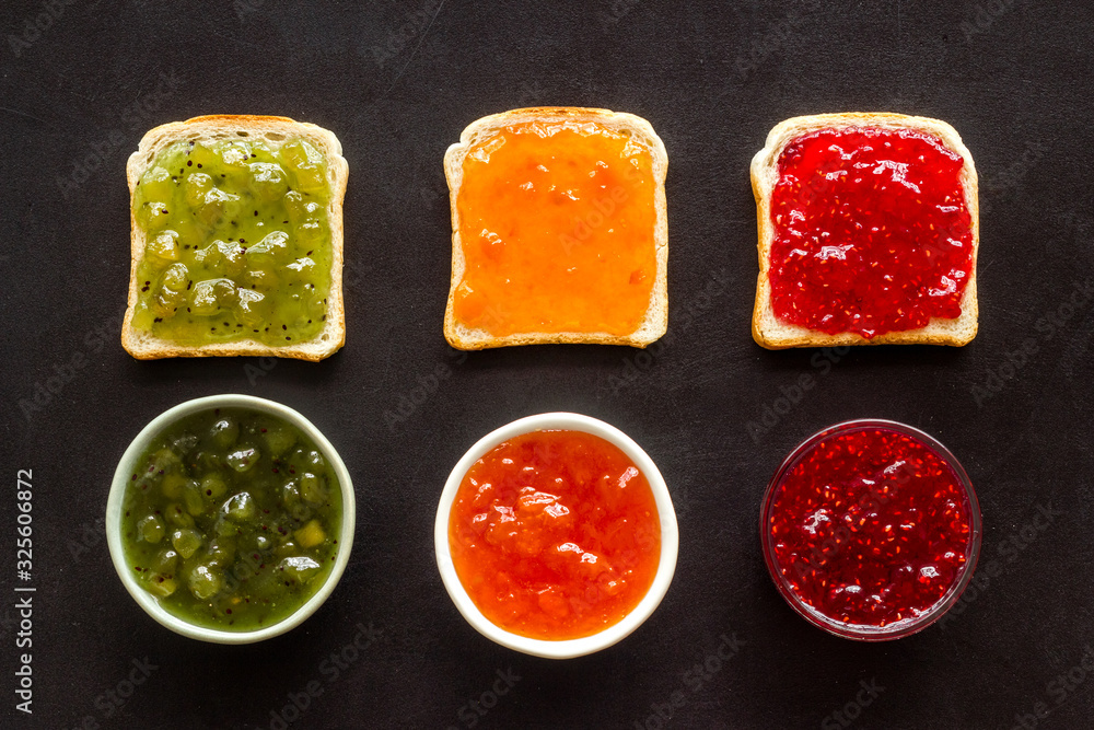 Toast with jam pattern on black background flat lay