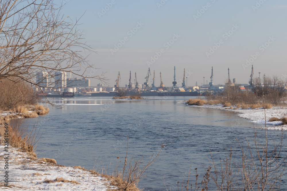 Spring landscape: view of the river port and port cranes across