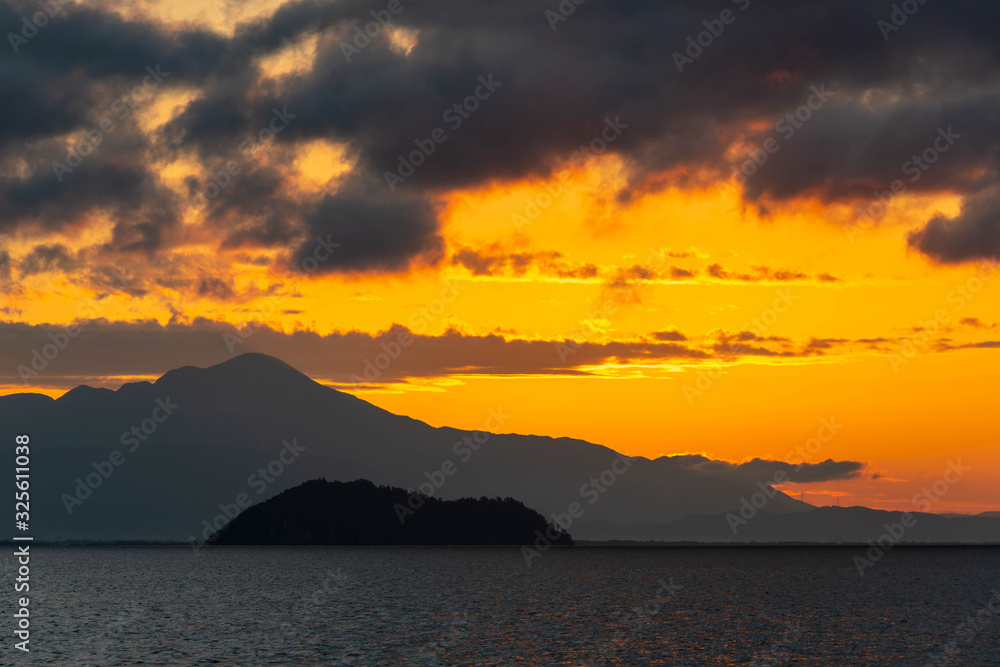 オレンジ色の朝の空と琵琶湖の竹島