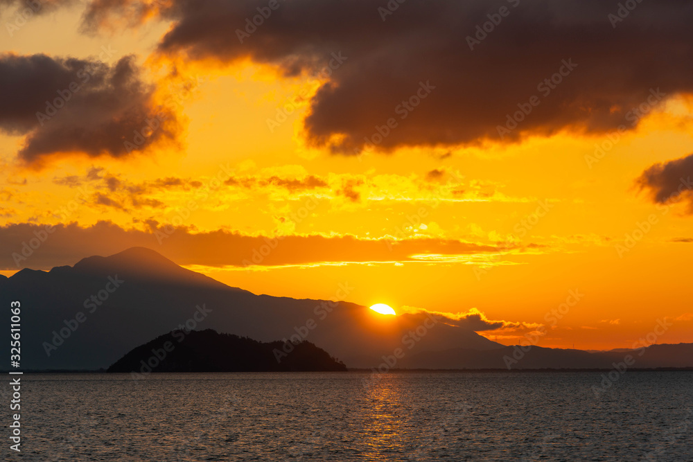 朝の空と琵琶湖の竹島から昇る太陽