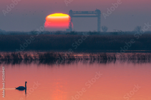 Winter sunrise on the Peene river near the Baltic Sea. In the picture remains of the lift bridge near Karnin.