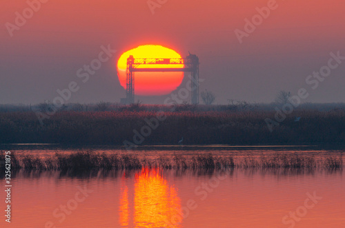 Winter sunrise on the Peene river near the Baltic Sea. In the picture remains of the lift bridge near Karnin.