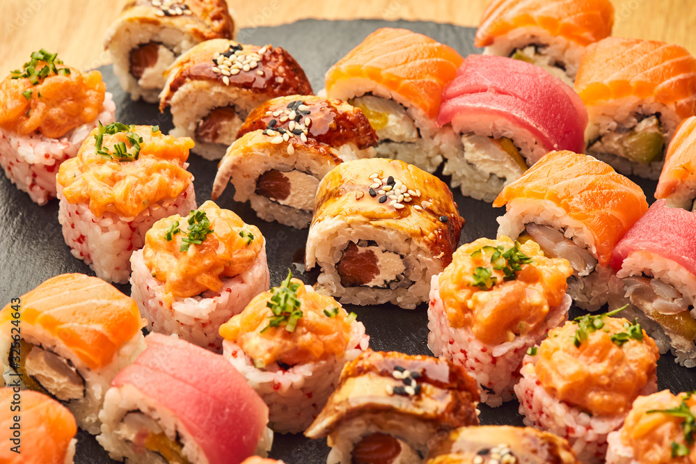 Various kinds of sushi roll set served on black stone. Japanese food Various kinds of sushi roll set served on black stone. Japanese food