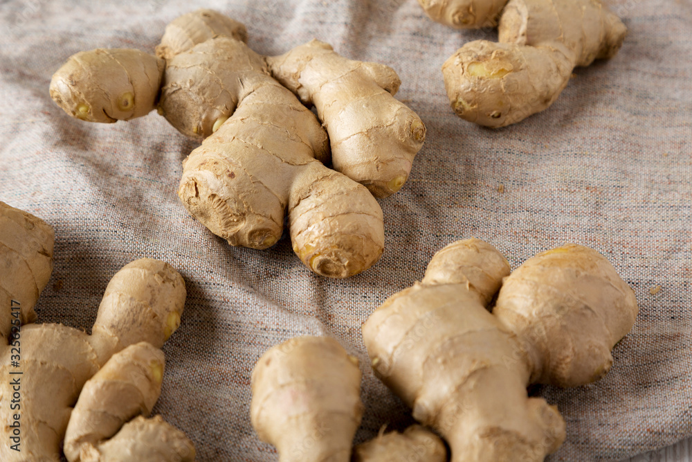Raw Organic Ginger Root on cloth, low angle view. Close-up. Raw Organic Ginger Root on cloth, low angle view. Close-up.