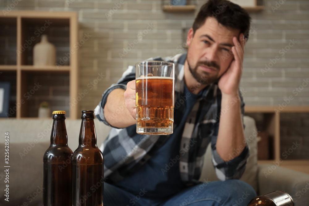 Man drinking beer at home. Concept of alcoholism Man drinking beer at home. Concept of alcoholism