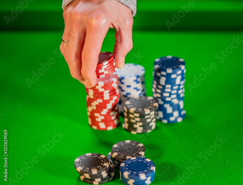 Poker player selecting chips to bet on a round in a game of Texas Holdem poker