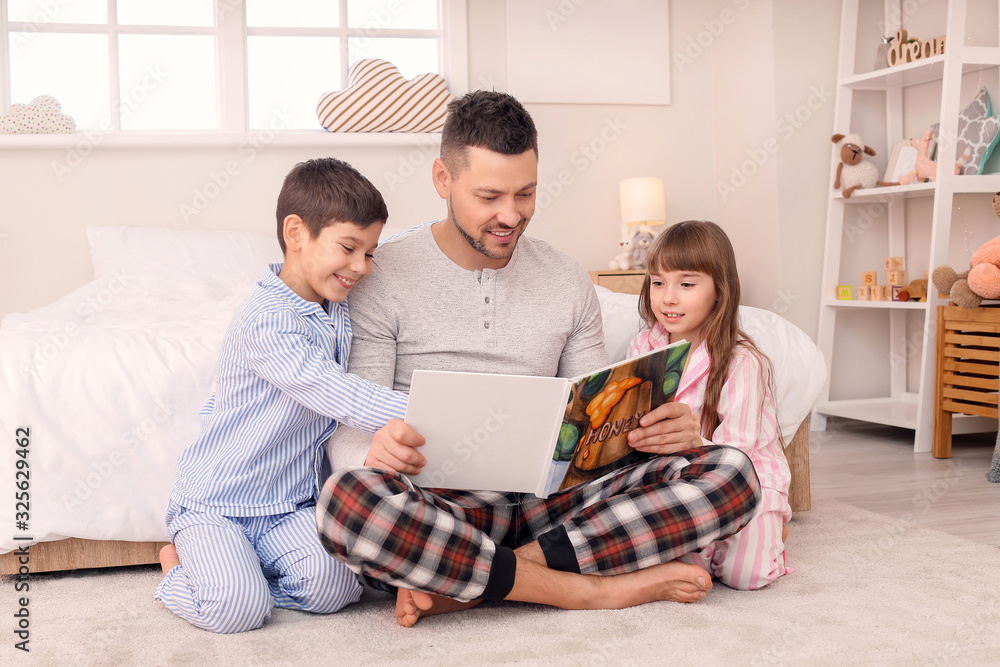 Father and his little children reading bedtime story at home Father and his little children reading bedtime story at home
