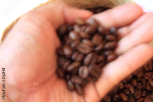 Defocused male hand touching coffee beans in the basket