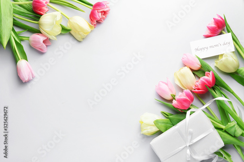 Fototapeta Naklejka Na Ścianę i Meble -  Beautiful flowers and gift for Mother's Day on white background