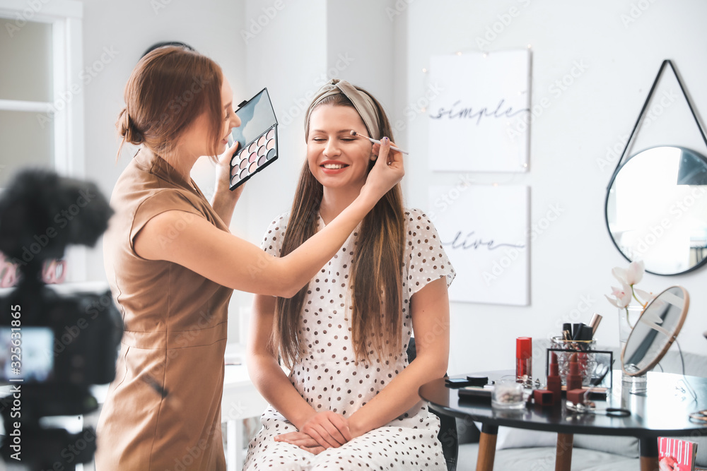 Young beauty blogger with model recording video at home Young beauty blogger with model recording video at home