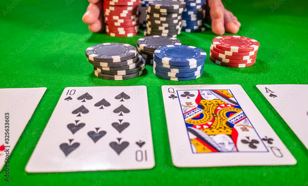 Close and selective focus on playing cards with a poker player going all in during a round of betting in soft focus Close and selective focus on playing cards with a poker player going all in during a round of betting in soft focus