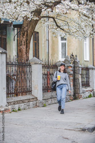 young stylish woman walking by street with coffee cup © phpetrunina14