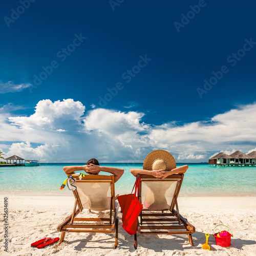 Fotografie, Obraz Couple in loungers on beach at Maldives