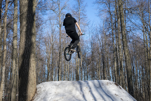 athlete jumping dirt jumping on bmx in winter
