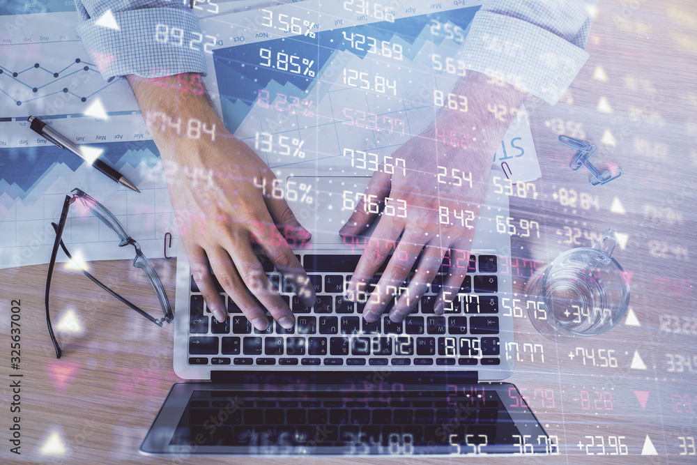 Double exposure of market chart with man working on computer on background. Concept of financial analysis.