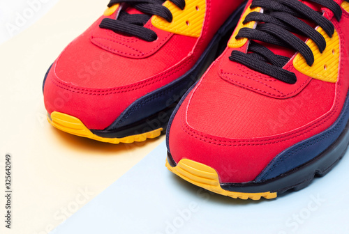Red sneakers on a blue and yellow background close up copy space