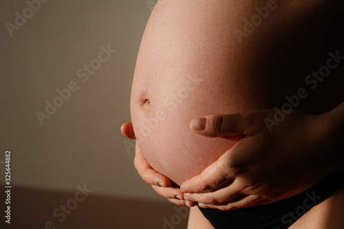Femme enceinte tenant son ventre avec ses mains photo
