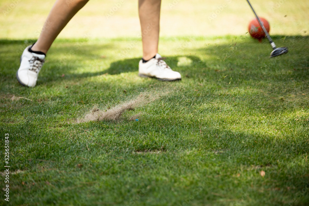 Close up golfer woman hit golf ball on green grass field Close up golfer woman hit golf ball on green grass field