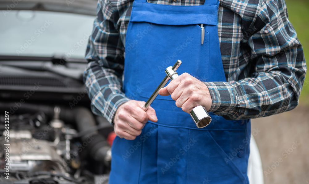 Car mechanic with car engine on background Car mechanic with car engine on background