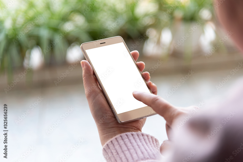 Female browsing mobile phone on spring home balcony