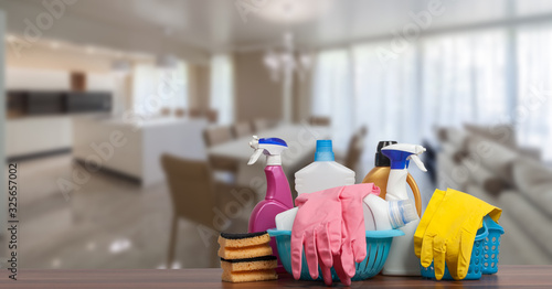 Home cleaning service concept with supplies. Close up of cleaning supplies in front of livingroom. photo