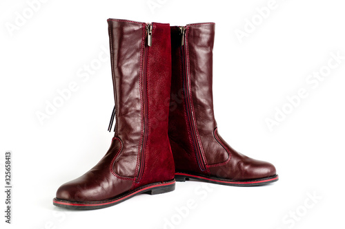 Women's leather boots in burgundy, fastened with a zipper. Background for women's shoes.
