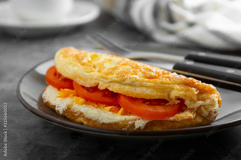 Omelet with cheese and tomatoes and a cup of coffee. Healthy homemade omelette for breakfast. Omelet with cheese and tomatoes and a cup of coffee. Healthy homemade omelette for breakfast.