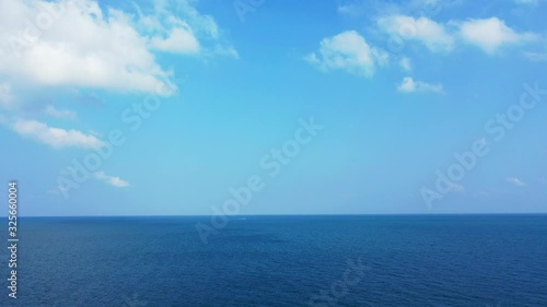 Deep ocean abstract background. Beautiful bright blue sky with fluffy white clouds above deep blue waters. photo