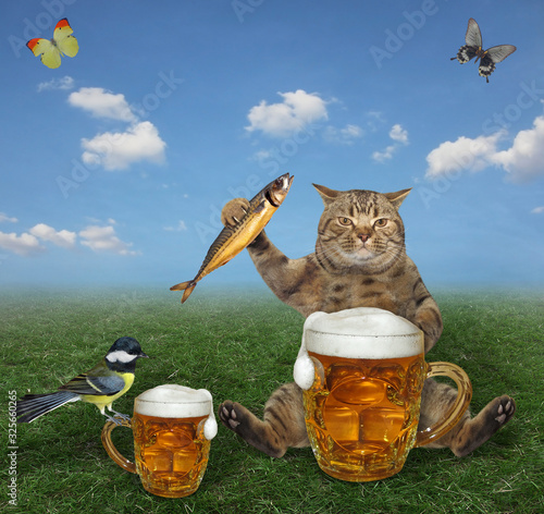 The beige cat is eating a smoked fish and drinking beer from a mug in the meadow. A titmouse is sitting next to him. Butterflies are flying nearby. photo