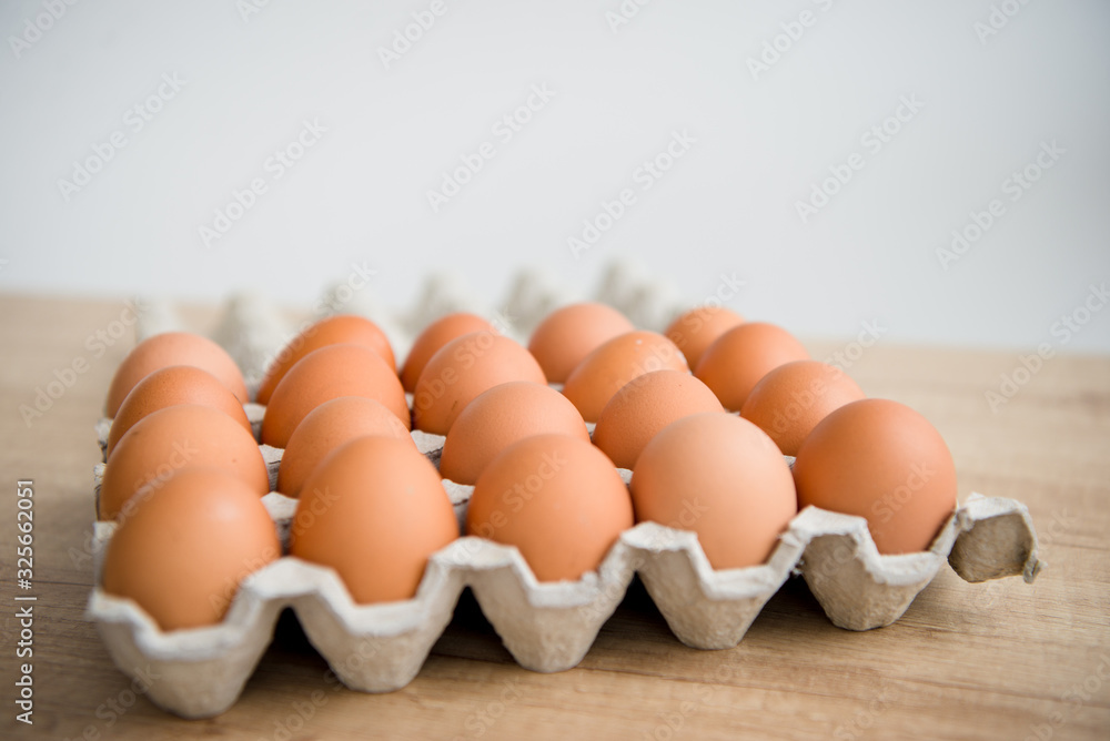 Hen eggs in paper carton box on background table. Organic products from farm. Copy space. Breakfast menu concept. Hen eggs in paper carton box on background table. Organic products from farm. Copy space. Breakfast menu concept.
