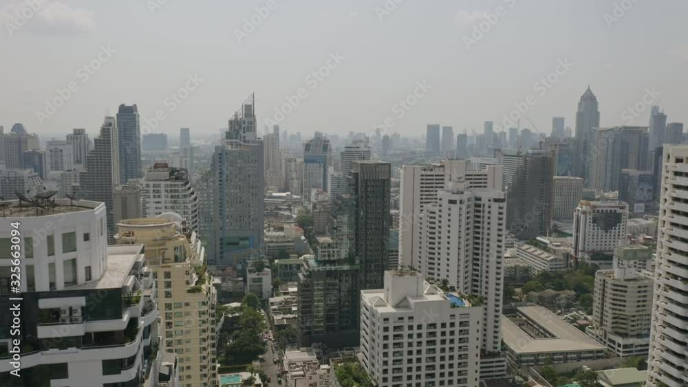 Bangkok Thailand Aerial v162 Flying low down between skyscrapers in Watthana and Soi Sukhumvit area with cityscape views - January 2020 Bangkok Thailand Aerial v162 Flying low down between skyscrapers in Watthana and Soi Sukhumvit area with cityscape views - January 2020
