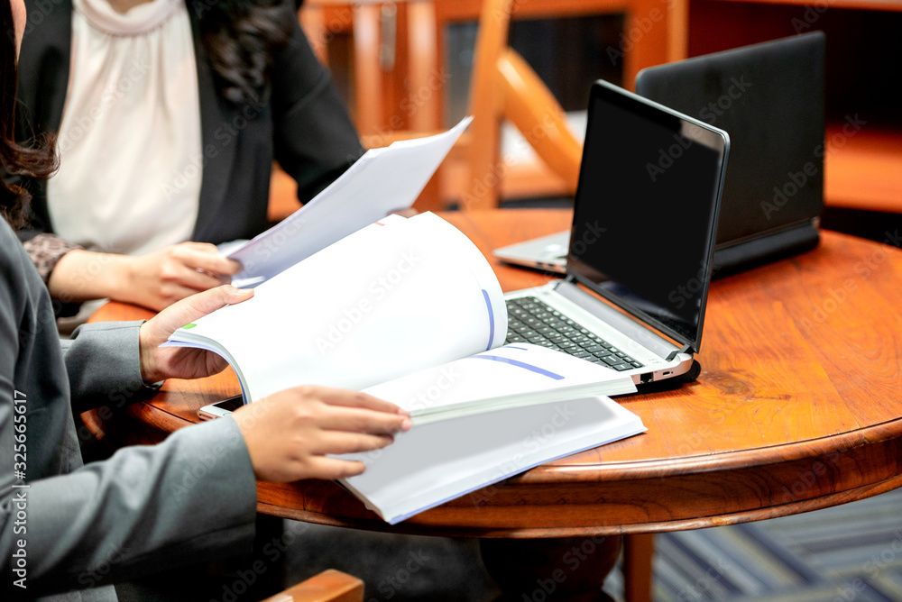 Businesswoman with laptop and document discussing business Businesswoman with laptop and document discussing business