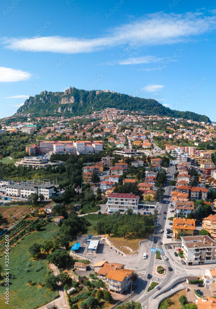 Aerial landscape view from distance on main city rock of San Marino Republic in the background. Vertical photo. The concept of the best places for tourism and journey. Down town, Italy