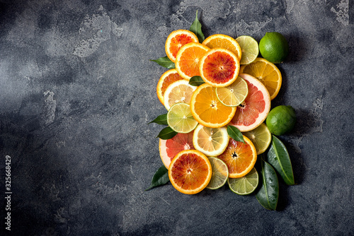 Fototapeta Sliced citrus fruits, top view, copy space background