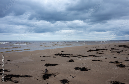 Fototapeta Naklejka Na Ścianę i Meble -  Clouds on a cloudy sky over the sandy beach of the Baltic Sea in Jurmala