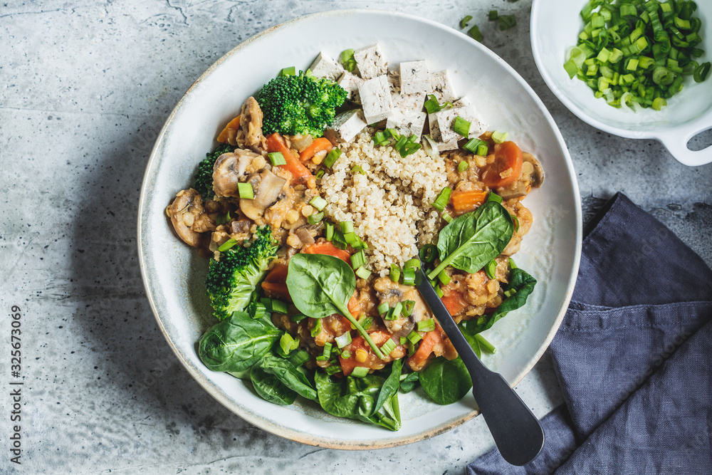 Lentil vegan stew with mushrooms, quinoa, spinach and broccoli in a bowl, top view. Healthy vegan food concept. Lentil vegan stew with mushrooms, quinoa, spinach and broccoli in a bowl, top view. Healthy vegan food concept.