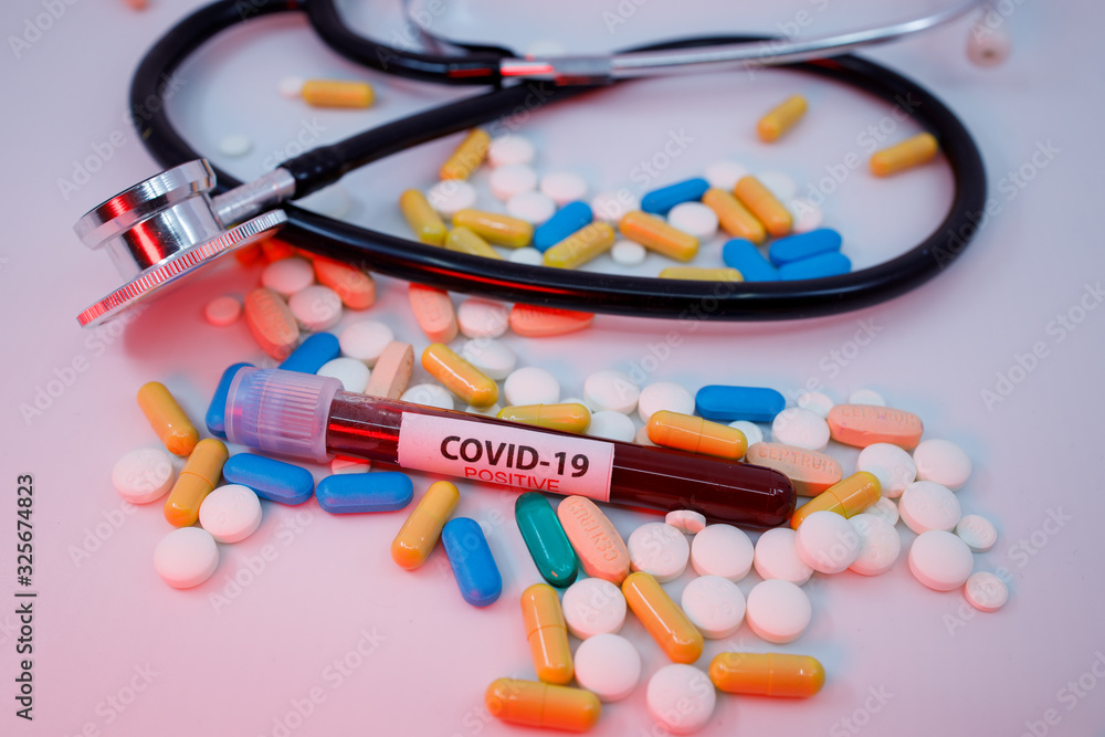 DUBAI, UAE - CIRCA 2020: Blood test tube for the new rapidly spreading Coronavirus that originated in Wuhan, China on a big pile of different type of medical pills and medical stethoscope. DUBAI, UAE - CIRCA 2020: Blood test tube for the new rapidly spreading Coronavirus that originated in Wuhan, China on a big pile of different type of medical pills and medical stethoscope.