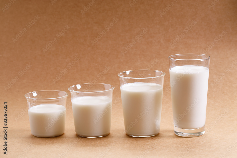 glasses of milk arranged as increasing height. glasses of milk arranged as increasing height.