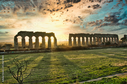 Ruin of the Roman Ancient Aqueduct in Rome, Beautiful sunset whit cloud sky in the background.