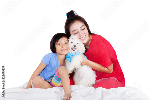 Asian woman and girl hugging their cute white dog