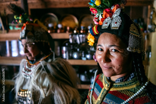 Portrait of women in typical tibetan clothes inside their house in Ladakh, Kashmir, India.