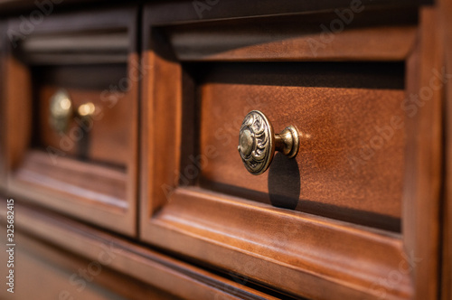 Wooden chest of drawers with metal handles closeup