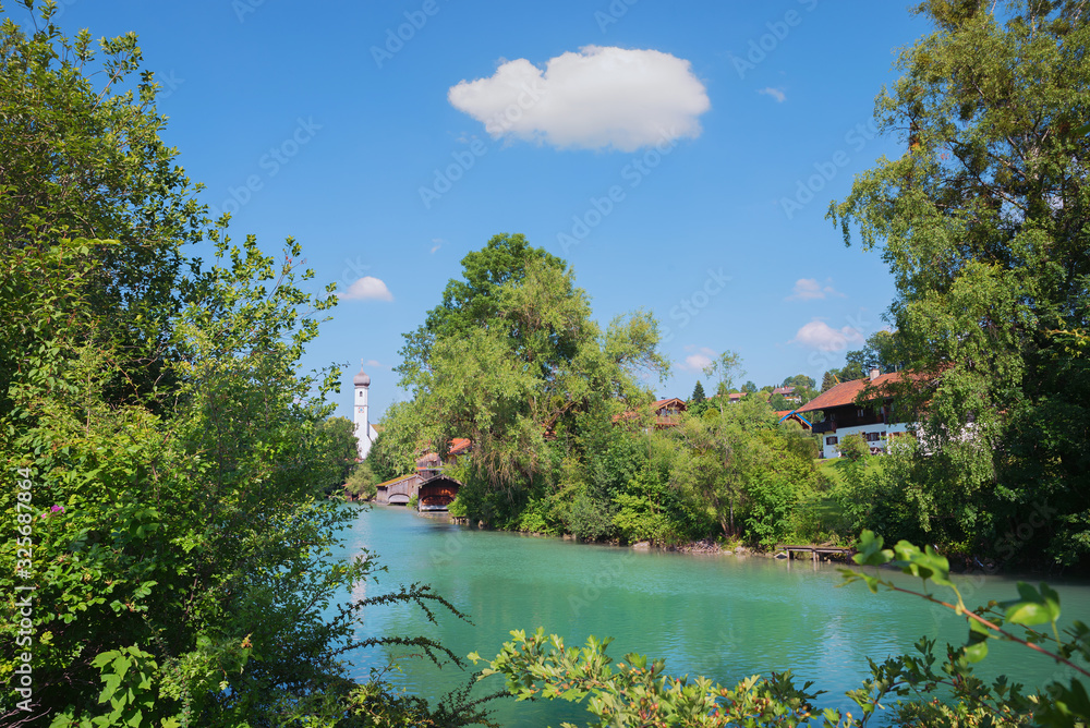 idyllic scenery  Mangfall river and green shrubs, church at Gmund village upper bavaria. blue sky with cloud