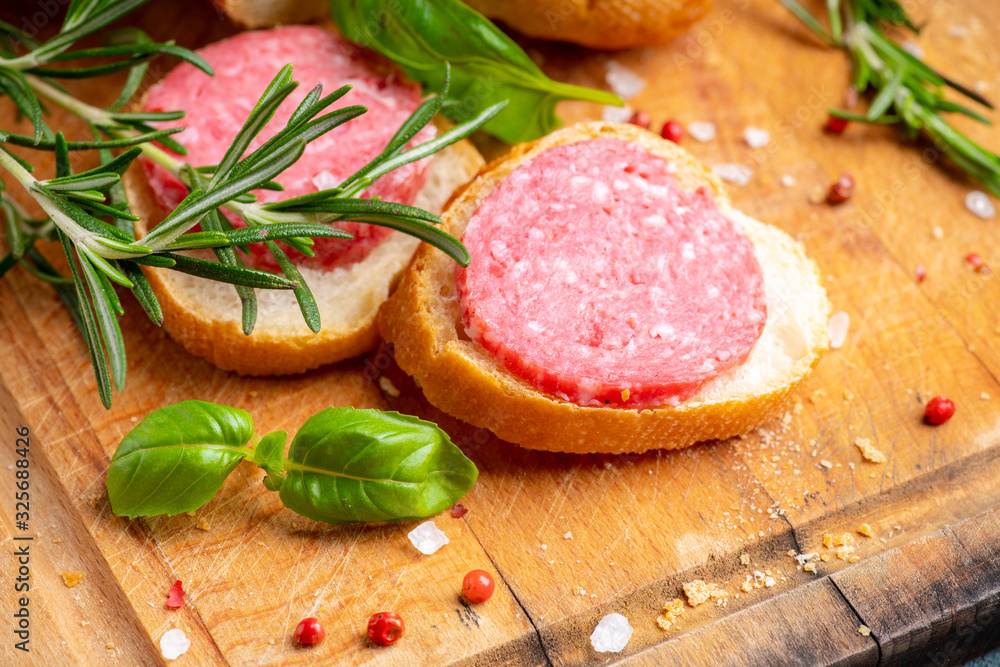 Bread with salami on the wooden background. Shallow depth of field. Bread with salami on the wooden background. Shallow depth of field.