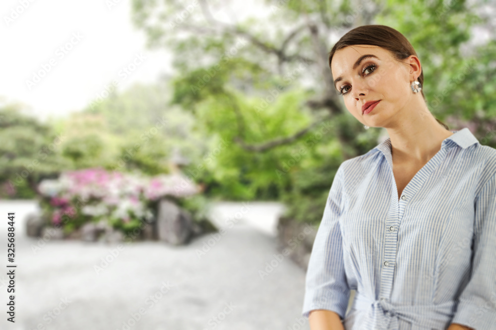 Slim young woman and spring time.Blurred landscape of garden Slim young woman and spring time.Blurred landscape of garden