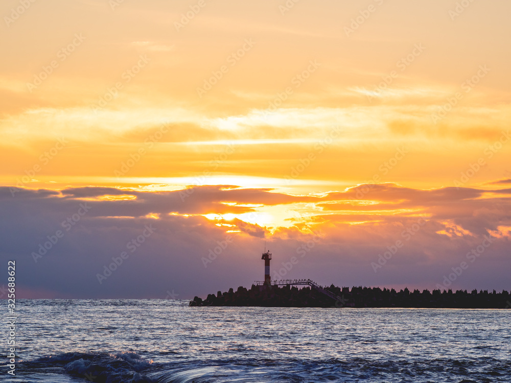Beautiful sunset over Black sea in Sochi, Russia. Silhouettes of lighthouse and seagulls on the railing. Beautiful sunset over Black sea in Sochi, Russia. Silhouettes of lighthouse and seagulls on the railing.