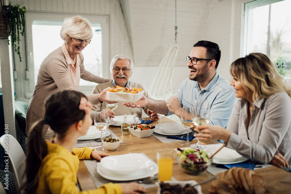 Happy extended family enjoying in lunch at dining table.
