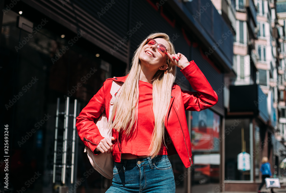 Fototapeta premium Happy girl walks down the street in spring around the city